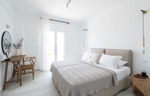 a bedroom with a bed and a desk and a mirror at Lourdas White Villa in Kefallonia