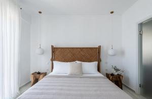 a bedroom with a large bed with white sheets at Lourdas White Villa in Kefallonia +38 photos