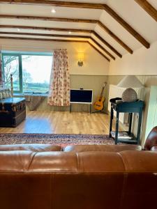a living room with a couch and a piano at Foyle View Glebe Barn in Tullyverry