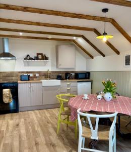 a kitchen with a table and chairs and a table and a kitchen at Foyle View Glebe Barn in Tullyverry +39 photos
