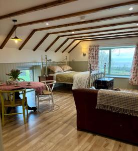 a living room with two beds and a table and a couch at Foyle View Glebe Barn in Tullyverry