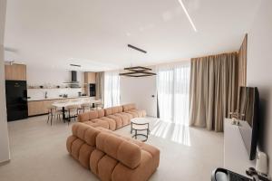 a living room with a large couch and a kitchen at Private Villa Ksamil in Ksamil