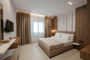 a bedroom with a bed and a desk and a television at Private Villa Ksamil in Ksamil +27 photos