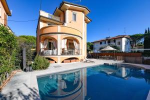 a house with a swimming pool in front of a house at Villa Bugatti Indipendent Villa ,lake view and private pool, DesenzanoLoft Official Partner Homes & Villas by Marriott Bonvoy in Desenzano del Garda