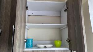 a closet with two white bowls and a yellow vase at Emerald Tulivu Place in Ruaka +4 photos