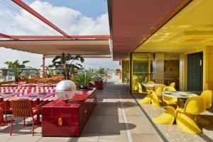 a restaurant with tables and chairs on a balcony at Moxy Barcelona in Barcelona