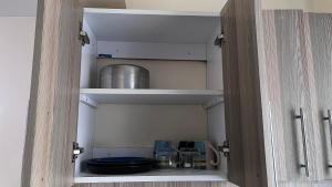 a cupboard with some items inside of it at Emerald Tulivu Place in Ruaka