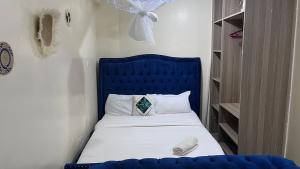 a bed with a blue headboard in a bedroom at Emerald Tulivu Place in Ruaka