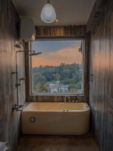 a bath tub in a bathroom with a window at Nature Breeze Boutique Villa in Kandy +37 photos