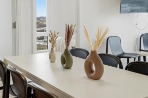 three vases sitting on a table in a room at Envitae Hotel 4BR Modern Sleek Apartment in Chicago