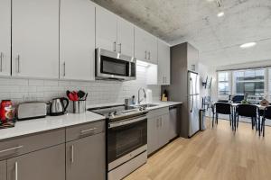 a kitchen with white appliances and a dining room at Envitae Hotel 4BR Modern Sleek Apartment in Chicago