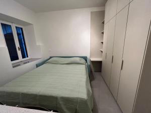 a small bedroom with a bed and a window at Oasi di pace in Domaso