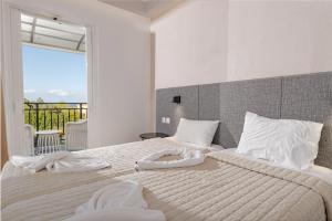 a bedroom with a large bed with towels on it at Villa Naisy in Tsilivi +8 photos