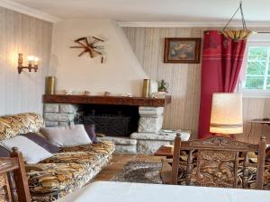 a living room with a couch and a fireplace at Charming Breton house in Hénansal in Hénansal