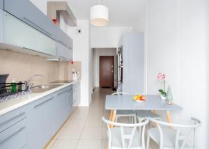 a kitchen with a blue table and white cabinets at Rooms Green Rydygiera 17 own private room tv wifi in Warsaw