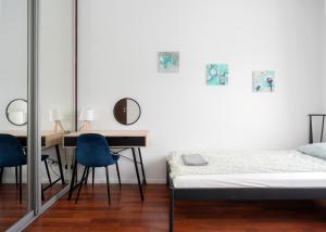 a bedroom with a bed and a desk and chairs at Rooms Green Rydygiera 17 own private room tv wifi in Warsaw