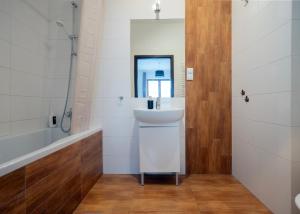 a bathroom with a sink and a tub and a mirror at Rooms Green Rydygiera 17 own private room tv wifi in Warsaw +15 photos
