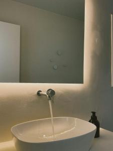 a bathroom sink with water running from a faucet at AELIA Tinos in Tinos +41 photos