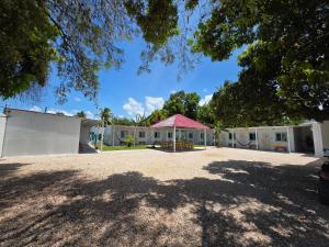a building with a pink roof and a pavilion at Hostal Estancia del Agua in Xul-Ha