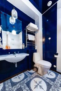 a blue bathroom with a toilet and a sink at Hotel Kupecheskiy Dom in Tomsk