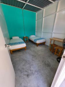 an empty room with two beds and a table at Hostal Estancia del Agua in Xul-Ha +15 photos