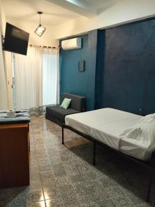 a bedroom with a bed and a couch in a room at Hostal Estancia del Agua in Xul-Ha