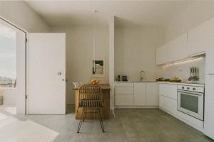a kitchen with a chair and a table in it at AELIA Tinos in Tinos