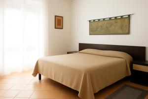 a bedroom with a bed with a tan blanket at Torre Ancinale in Soverato Marina