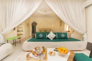a bedroom with a large bed with a table with fruit on it at Palais les sources de l'atlas, Padel & spa in Marrakesh