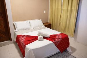 a bedroom with a bed with a red and white blanket at Hostel House Santinho in Florianópolis +36 photos