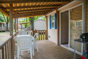 a wooden porch with a table and chairs on it at Camping Parc Bellevue - Maeva in Cannes