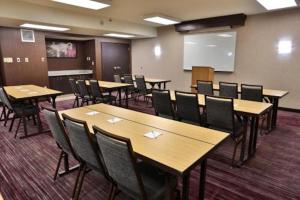 a conference room with tables and chairs and a whiteboard at Hotel Preston by IHG in Montgomery