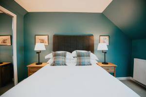 a bedroom with a large bed with blue walls at The Seafield Arms Hotel Cullen - Self Catering in Cullen