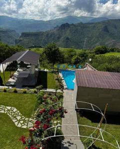 a house with a swimming pool and mountains in the background at Sunny Village Hotel in Haghpat