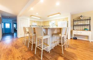 a kitchen with a counter and a bar with stools at Fly Boys - Nags Head MP 12.5, Oceanfront, Ocean View, Elevator, Pool Table, Hot Tub, YR Flex in Nags Head
