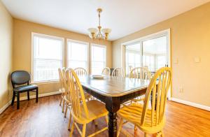 a dining room with a wooden table and chairs at Fly Boys - Nags Head MP 12.5, Oceanfront, Ocean View, Elevator, Pool Table, Hot Tub, YR Flex in Nags Head