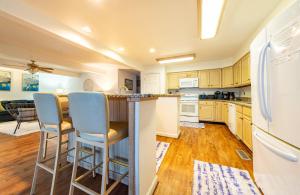 a kitchen with a counter and chairs in it at Fly Boys - Nags Head MP 12.5, Oceanfront, Ocean View, Elevator, Pool Table, Hot Tub, YR Flex in Nags Head +43 photos