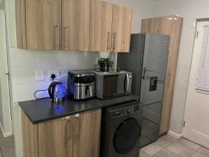 a kitchen with a microwave and a refrigerator at Valley Escape in Cape Town