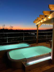 a hot tub on a deck with a pergola at Little Pig Glamping in Bude