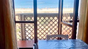 a table and chair on a balcony with a view of the beach at RM06 - Senigallia, trilocale fronte mare in Senigallia