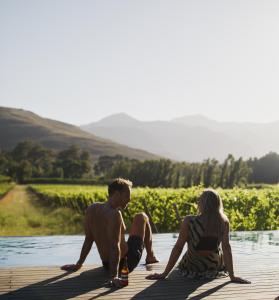 a couple sitting on a dock by the water at MAISON FRANSCHHOEK in Franschhoek +94 photos