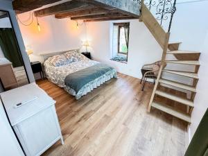 a bedroom with a bed and a staircase in it at La Maisonnette de Carreaux in Azay-le-Rideau