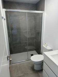 a bathroom with a toilet and a glass shower at El Merendero in Utrera