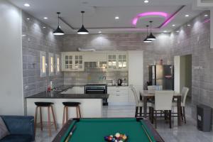 a kitchen with a pool table in a room at شاليه درة رأس الجنز Dorrat Ras Al Jinz Chalet in Junayz al Janūbī