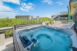 a jacuzzi tub on a balcony of a house at Dunes for Days - Nags Head MP 12.5, Oceanfront, Hot Tub, Rec Room, Pets OK, YR Flex in Nags Head