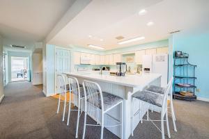 a kitchen with a white island with bar stools at Dunes for Days - Nags Head MP 12.5, Oceanfront, Hot Tub, Rec Room, Pets OK, YR Flex in Nags Head