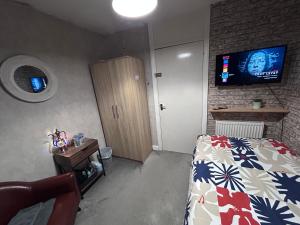 a bedroom with a bed and a tv on the wall at Park House in Leicester
