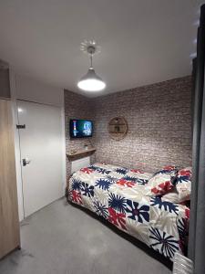 a bedroom with a bed and a tv on a brick wall at Park House in Leicester