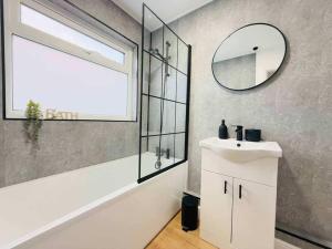 a bathroom with a white sink and a mirror at 4 Bedroom House in Port Talbot with Parking, Near M4, Ideal for Contractors in Port Talbot +31 photos