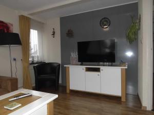 a living room with a flat screen tv on a white cabinet at Welca in Baarlo